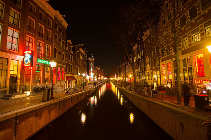Imagem de canal na red light distric a noite em Amsterdam.